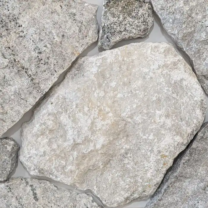 Tullah loose random wall cladding featuring light to medium grey natural stone with subtle golden tones and shimmer for exterior stone feature walls.
