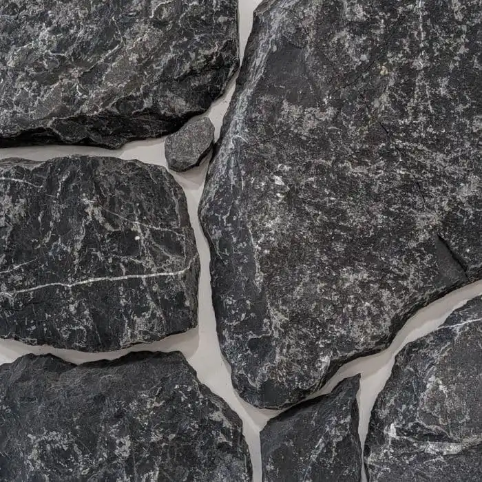Dark charcoal Midnight limestone wall cladding with natural white quartz veining and textured rocky edges for modern outdoor feature walls.